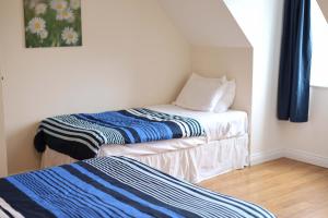 two beds in a small room with blue curtains at Long Quay Apartments, Clonakilty in Clonakilty