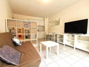 a living room with a couch and a flat screen tv at Studio Zen hypercentre parking privé WIFI in Salon-de-Provence