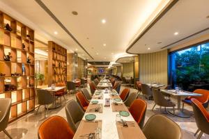 a dining room with long tables and chairs at Express Inn The Business Luxury Hotel in Nashik
