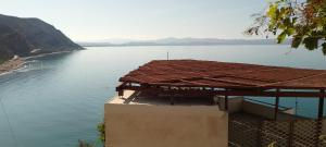 a building with a roof over a body of water at Loggia in Agia Galini