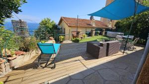 Maison avec jardin, vue mer aux portes de Monaco في بوسولاي: شخص يجلس على سطح خشبي مع كرسي
