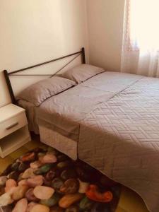 a bedroom with a bed with a pile of rocks on the floor at house with sea and mountain view in Rozená