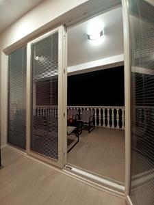 una camera con una grande porta scorrevole in vetro con tavolo di Apartman Christina a Bilice (Bilizze)