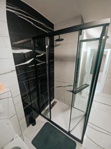 una doccia con porta in vetro in bagno di Apartman Christina a Bilice (Bilizze)