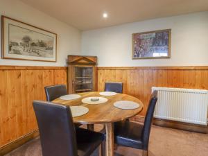 a dining room with a wooden table and chairs at Old Bar House in Keighley