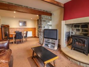 a living room with a fireplace and a tv at Old Bar House in Keighley