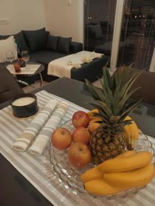 a plate of fruit on a table in a living room at Apartman Christina in Bilice
