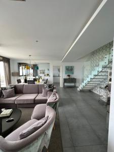 una sala de estar con 2 sofás y una escalera en DÚPLEX DE LUJO EN FOZ CON VISTAS al MAR, en Foz