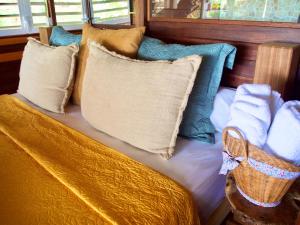 una cama con almohadas en una habitación en Le Karbé Bakov, en Rémire-Camp