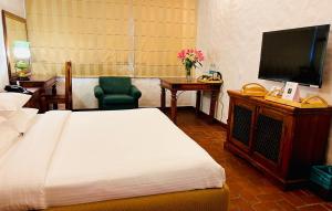 Schlafzimmer mit einem Bett und einem Flachbild-TV in der Unterkunft The Kaptain's Retreat in Chandīgarh