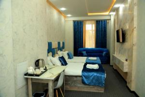 杜尚别Green Hotel Dushanbe的配有床和书桌的酒店客房