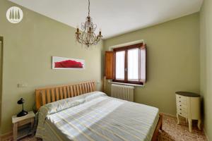 a bedroom with a bed and a chandelier at Agriturismo Irto Colle in Massa e Cozzile