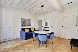 Pick A Flat's Apartment in Jardin du Luxembourg - Rue Royer Collard في باريس: غرفة معيشة مع أريكة زرقاء وطاولة