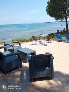 a group of chairs and tables next to the ocean at Studios Efi beach in Vourvourou