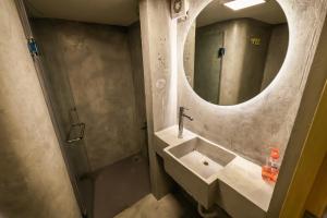 een badkamer met een wastafel en een spiegel bij Old Town Guesthouses in Batroûn