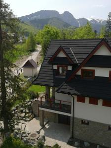 a house with a black roof and a road at Willa Nika, Apartamenty in Zakopane