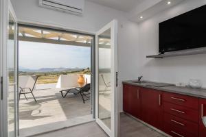 a kitchen with a sliding glass door leading to a patio at Sunset Village 6 in Paleochori