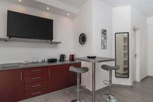 a kitchen with a bar with a tv on the wall at Sunset Village 6 in Paleochori