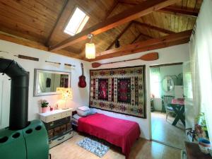 a bedroom with a red bed and a stove at Domek nad Poranną Rosą in Garbatka-Letnisko