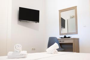 a bedroom with a tv and a chair and a desk at Casa Fabrica in Ano Syros