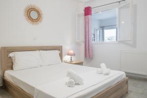 a bedroom with a large white bed and a window at Casa Fabrica in Ano Syros