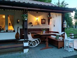 eine Veranda eines Hauses mit einem Tisch und einer Bank in der Unterkunft Domek nad Poranną Rosą in Garbatka-Letnisko