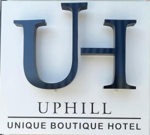 スキアトスタウンにあるUphill Unique Boutique Suitesのユニークなブティックホテルウキルを読むサイン