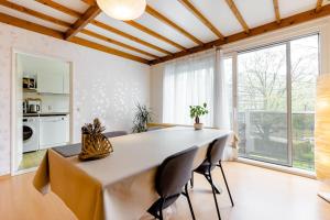 uma sala de jantar com uma grande mesa e cadeiras em Digital Nomad Station - Bedroom with Desk nearby Station and Parking with singing birds each morning em Antuérpia