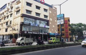 een gebouw met vrachtwagens voor een straat bij Gokul Residency Near Emami City Nager bazar in Dum Dum