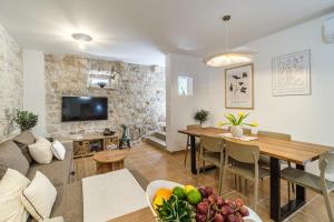 Una sala de estar con un sofá y un comedor. en Villa Nora - Charme Holidays, en Sutivan