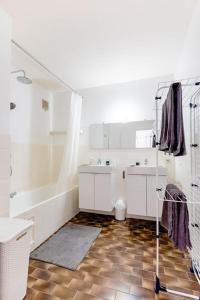 y baño con bañera, 2 lavabos y ducha. en Digital Nomad Station - Bedroom with Desk nearby Station and Parking with singing birds each morning, en Amberes