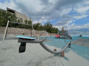 a playground in a pool with a swing at Apartments Tara in Ražanac