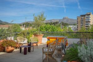 eine Terrasse mit Stühlen und einem Tisch auf dem Balkon in der Unterkunft Best Western Linko Hôtel in Aubagne