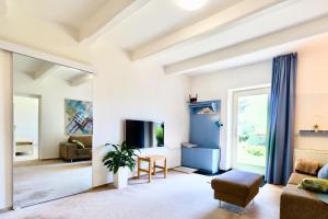 uma sala de estar com um sofá e uma televisão em Svůj vlastní soukromý ráj-nájem apartmánu v Berouně! em Beroun