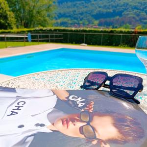 a pair of sunglasses sitting on a table next to a swimming pool at Casa Vacanze Alessandro in Spinone Al Lago