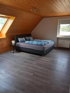 a bedroom with a large bed in a attic at Ferienwohnung am Waldrand in Bechhofen