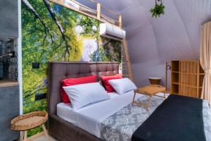 1 dormitorio con 1 cama con una pintura en la pared en luxury dome tents ikaria ap'esso2, en Raches
