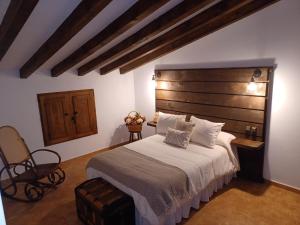a bedroom with a large bed with a wooden headboard at El Rincón de BeBa in Segura de la Sierra