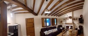 a living room with a ceiling with wooden beams at El Rincón de BeBa in Segura de la Sierra