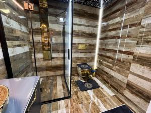 y baño con ducha y pared de madera. en Квартира Versace 3+1 в Анталии en Hurmaköy