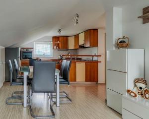 a kitchen with a table and chairs and a refrigerator at Apartma Hilltop Haven in Šmarje pri Jelšah