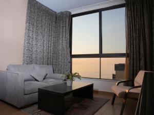 sala de estar con sofá, mesa y ventana en Marbella Hotel en Jounieh