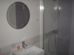 a bathroom with a sink and a shower with a mirror at Katerina Lefkada in Vasiliki