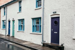 a white building with a purple door on a street at The Old Brewery, Ulverston in Ulverston