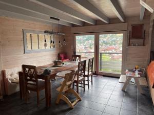 une cuisine avec une grande table et des chaises en bois dans l'établissement Le chalet blanc de Gerardmer avec Spa, à Gérardmer