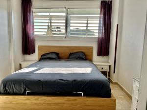 um quarto com uma cama grande e uma janela em Apartamento Platja d 'aro, 5 camas 2 dormitorios em Platja d'Aro