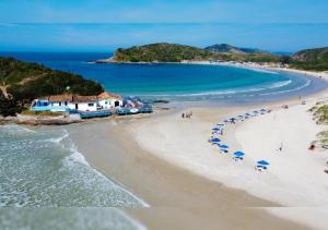 a view of a beach with umbrellas and the ocean at Pousada Bellmar Peró - Praia e Comércio 8 min andando in Cabo Frio