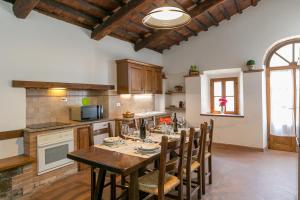 cocina con mesa y sillas en Villa Adelmo, en Pomarance