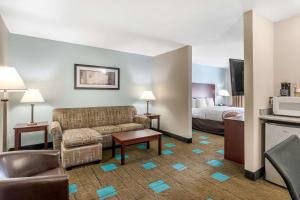 Quality Suites Kansas City International Airport في كانساس سيتي: غرفة في الفندق مع أريكة وسرير