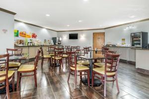 un restaurante con mesas y sillas de madera y una barra en Quality Suites Kansas City International Airport en Kansas City